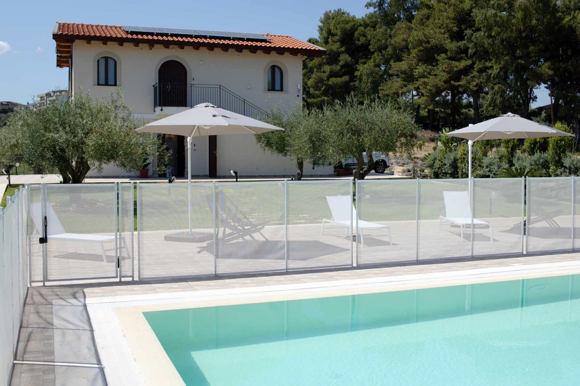 Casa in stile mediterraneo e piscina con ombrelloni e lettini dell'Agriturismo Casarancio vicino Milazzo