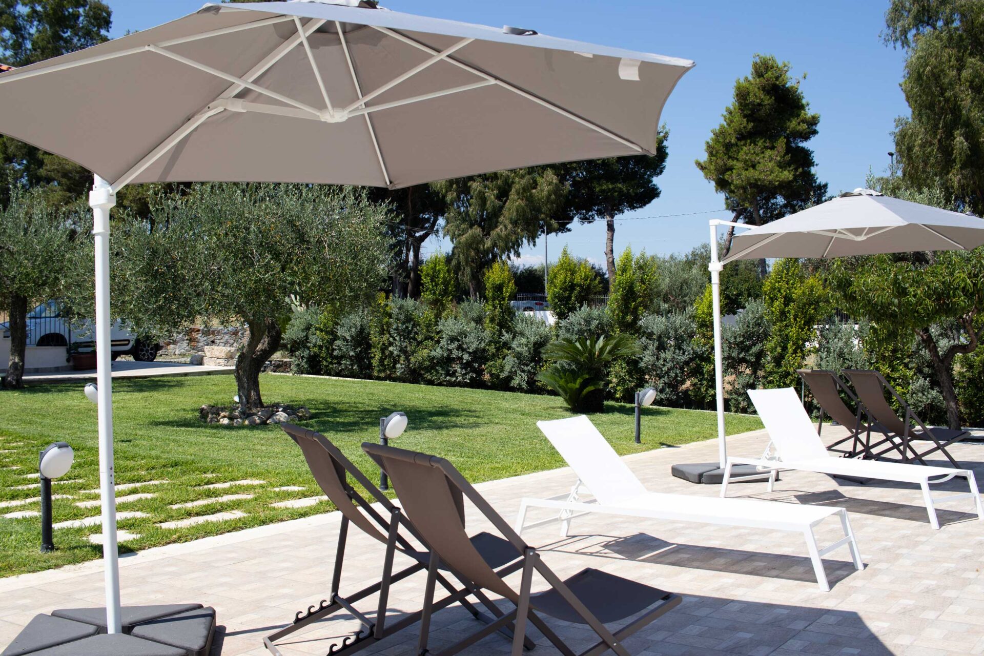 Prendisole con ombrelloni accanto alla piscina dell'Agriturismo Casarancio vicino Milazzo